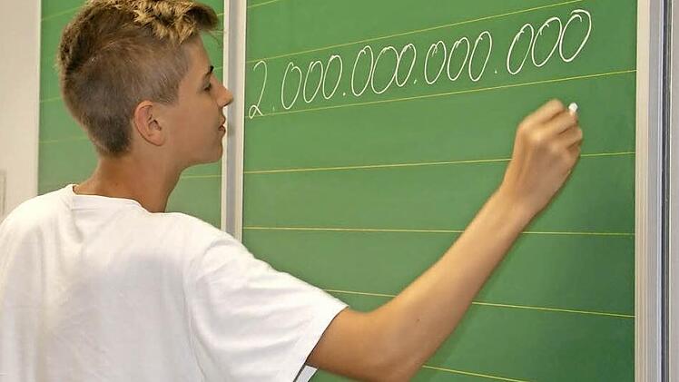 Wie viele Schulden hat Deutschland? Sebastian macht es kein Problem, zwei Billionen Euro mit der richtigen Zahl von Nullen an die Tafel zu schreiben.