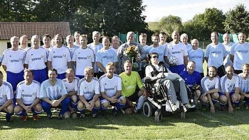 Die "Allstars" Haßberge (weiße Hemden) und die Traditionself der Sportfreunde Holzhausen (hellblaue Trikots) lieferten sich in Mechenried ein Fußballspiel, dessen Reinerlös der Unterstützung von Jonas Thein aus Uchenhofen zugute kommt. Rechts steht der Schiedsrichter Willi Fuß aus Zell. Foto: Gerold Snater