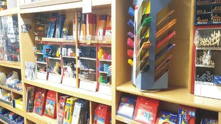 Ein Schreibwarengeschäft zeigt volle Regale mit Stiften, Papier und Farben. Der Ausverkauf deutet auf eine bevorstehende Schließung nach über vier Jahrzehnten hin.