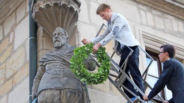 Tradition, Tradition: Der erste Kranz kommt an den Arm der Fürstenstatue, der zweite auf den Kopf. Ganz oben auf der Leiter steht der Festredner (Max Bauer), danach kommen die fünf Jahrgangsbesten der Q11, angeführt von Michael Engel. Nach der Bekränzung muss der Festredner noch drei Gläser Bier austrinken und zu Boden werfen.  Foto: Simone Bastian