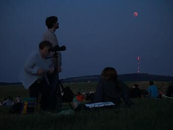 Da ist er! Mit Teleobjektiv und Ferngläsern hatten sich die Menschen ausgerüstet, um den Blutmond zu beobachten. Foto: Marion Eckert