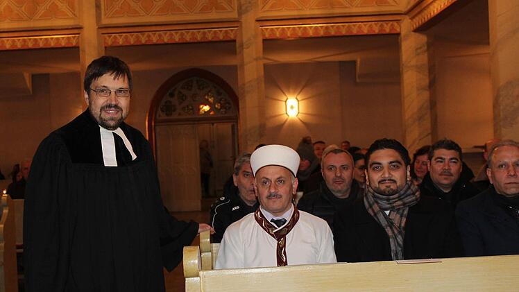 Beeindruckt nimmt Imam Osman Harbi Platz im evangelischen Gotteshaus. Pfarrer Martin Frenkler begr&uuml;&szlig;t alle. Foto: Manja von Nida