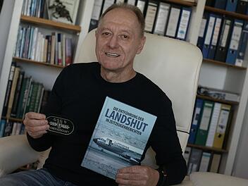 Aribert Martin in seiner Fuldaer Wohnung mit einem GSG9-Abzeichen und einem Buch, in dem auch seine Erlebnisse in Mogadischu aufgeschrieben sind.  Foto: Steffen Standke