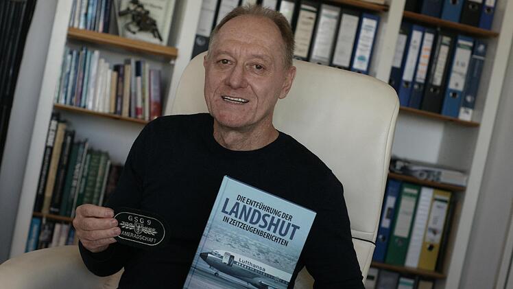 Aribert Martin in seiner Fuldaer Wohnung mit einem GSG9-Abzeichen und einem Buch, in dem auch seine Erlebnisse in Mogadischu aufgeschrieben sind.  Foto: Steffen Standke