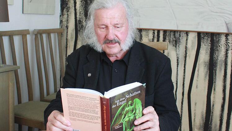 Ingo Cesaro beim Blick in den Band "Aus dem Schatten der Engel", in dem auch das prämierte Gedicht "Es ist keine Legende" veröffentlicht ist. Im Vordergrund zwei neue Gedichtbände des Künstlers. Foto: Friedwald Schedel
