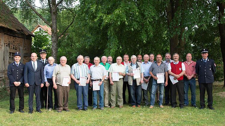 Geehrte und Festgäste: (von links) Vorsitzender Matthias Schmitt, 2. Bürgermeister Michael Kastl, Kreisbrandinspektor Edwin Frey, Walter Kirchner, Bernhard Scherlenz, Bruno Memmel, Siegfried Pfisterer, Ehrenkommandant Willi Beck, Herbert Helbig, Burkard Büscher, Otto Schmitt, Paul Schmitt, Libor Katzenberger, Winfried Groten, Edmund Fries, Albert Biebrich, Robert Reuscher, Gerhard Back, Waldemar Schmitt, Ortssprecher Klaus Görlinger und Kommandant Dominik Kuhn.Foto: Björn Hein
