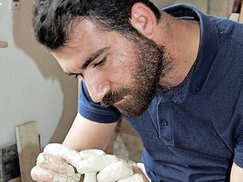 Konzentriert gestaltet Kunststudent Mehmet Demir (22) auf der Töpferscheibe eine elegante Vase