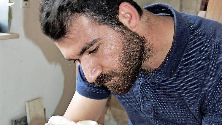 Konzentriert gestaltet Kunststudent Mehmet Demir (22) auf der Töpferscheibe eine elegante Vase