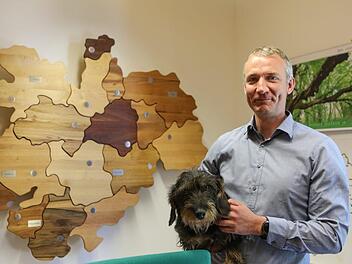 Nat&uuml;rlich aus Holz: Der neue Gesch&auml;ftsf&uuml;hrer der FVO J&ouml;rg Ermert und Dackel J&uuml;nni vor der besonderen Oberfrankenkarte in Ermerts neuem B&uuml;ro. Barbara Herbst