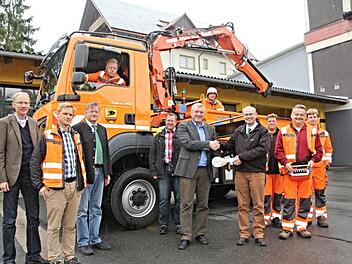 Bürgermeister Jürgen Hennemann (Sechster von rechts) nimmt aus den Händen von Armin Zwingmann (Vierter von rechts) symbolisch den Fahrzeugschlüssel für den neuen Lkw entgegen. Weiter auf dem Foto (vorne von links) Bauamtsleiter Martin Lang, Bauhofleiter Christian Raehse, Baywa-Kommunalvertriebsleiter Roland Breunig, Stefan Hofmann vom Bauamt und weitere Mitarbeiter des Bauhofes Ebern.  Foto: Helmut Will