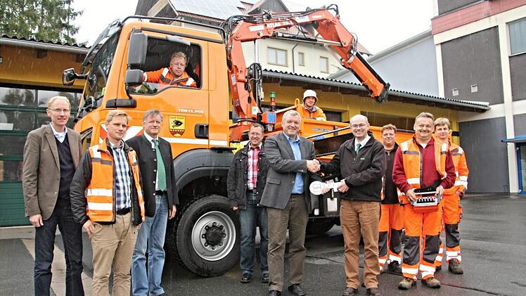 Bürgermeister Jürgen Hennemann (Sechster von rechts) nimmt aus den Händen von Armin Zwingmann (Vierter von rechts) symbolisch den Fahrzeugschlüssel für den neuen Lkw entgegen. Weiter auf dem Foto (vorne von links) Bauamtsleiter Martin Lang, Bauhofleiter Christian Raehse, Baywa-Kommunalvertriebsleiter Roland Breunig, Stefan Hofmann vom Bauamt und weitere Mitarbeiter des Bauhofes Ebern.  Foto: Helmut Will