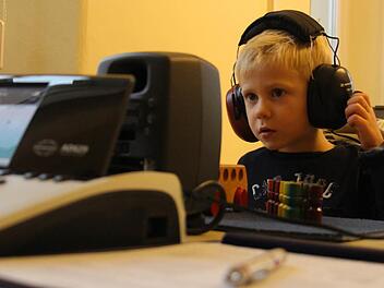 Der vierjährige Lennox konzentriert sich auf den Hörtest beim Gesundheitsamt. Foto: Christian Bauriedel