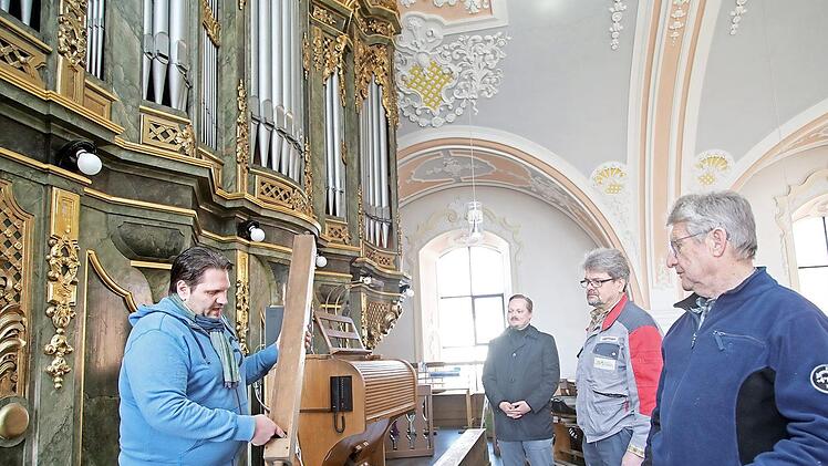 Orgelbauer Karsten Hörl aus Helmbrechts (links) erklärt an einer gedeckten Pfeife aus Kiefernholz, welche Schritte bei der Sanierung notwendig sind. Mit im Bild (nach rechts) Pfarrvikar Sebastian Masella, Jürgen Porzelt und Kirchenpfleger Klaus Geier