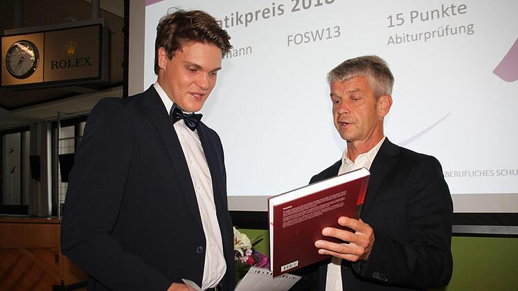 Der Preis für die beste Mathematikprüfung geht an Lukas Holzmann (links) aus Rugendorf. Oberstudienrat Christian Schröppel schenkt ihm ein Buch.