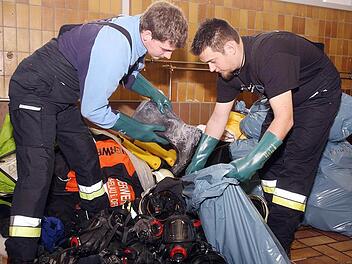 Totalschaden in Michelau:  Zweiter Kommandant  Andre Gagel (links) und Patrik Naumann  mussten  im  März nach dem verheerenden Feuer bei der Firma "Metob" massenhaft Ausrüstungsgegenstände entsorgen. Ihren  Kollegen im Landkreis Coburg ging es nicht anders - und  jetzt gibt es auch noch Ärger darum, wie der Schaden bezahlt wird. Foto: Stefan Johannes