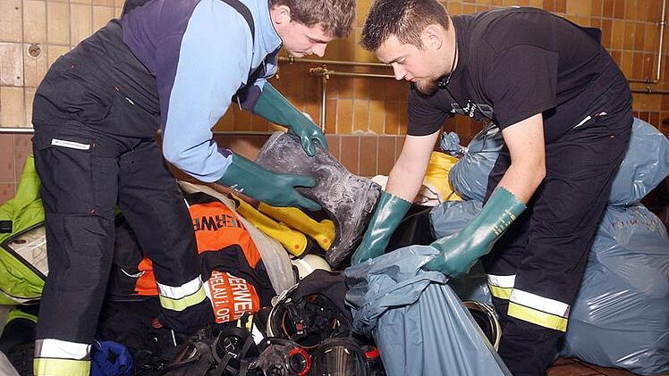 Totalschaden in Michelau:  Zweiter Kommandant  Andre Gagel (links) und Patrik Naumann  mussten  im  März nach dem verheerenden Feuer bei der Firma "Metob" massenhaft Ausrüstungsgegenstände entsorgen. Ihren  Kollegen im Landkreis Coburg ging es nicht anders - und  jetzt gibt es auch noch Ärger darum, wie der Schaden bezahlt wird. Foto: Stefan Johannes