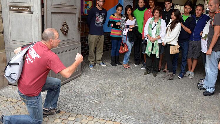 Schweigsame Jugendliche beim Betrachten der Kissinger Stolpersteine, steht doch jeder Stein für einen gestorbenen Juden, der einst hier wohnte. Edwin Metzler erklärte den Gästen den Sinn der Stolpersteine. Fotos: Peter Rauch