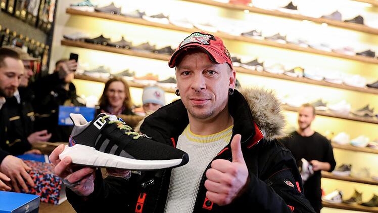 Steven Fischer zeigt am 16.01.2018 in Berlin als erster Käufer in dem Sneaker-Schuhladen seine neuen Adidas-Turnschuhe mit eingebauter BVG-Jahreskarte. Foto: Kay Nietfeld/dpa