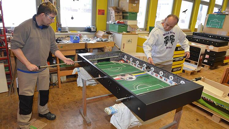 Christian Steger (links) und Jürgen Meister montieren die Kickerstangen.