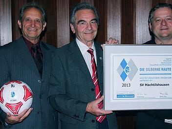 Edgar Wolf, 3. Bürgermeister und Ehrenamts-Beauftragter, und Kreisehrenamtsbeauftragter Georg Stöth überreichen die "Silberne Raute" an den SV-Vorsitzenden Volker Meusel-Schneider (r.). Foto: Gerd Schaar