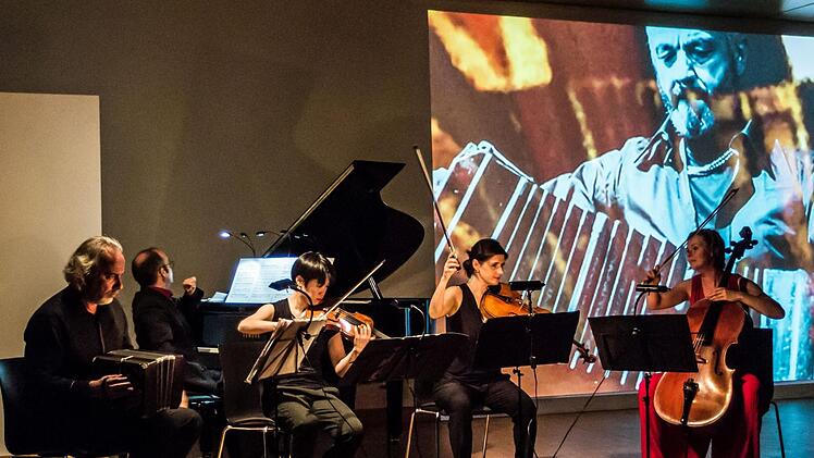 Faszinierende Kombination: Gemeinsam mit dem Bandoneon-Virtuosen Kostas Raptis musizierte das Flex Ensemble in Coburg. Zur Musik präsentierte Tosh Leykum Video-Sequenzen.Foto: Jochen Berger