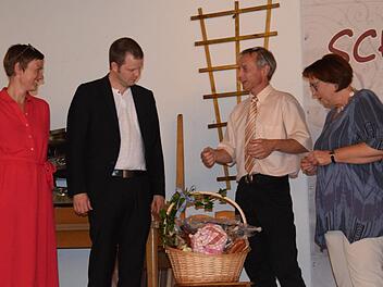 Christiane Binder-Jung (Kirchengemeinde Heiligkreuz), Reinhold Samer (Kirchengemeinde Weißenbach) übereichen dem Ehepaar Dr. Katharina Eberlein-Braun und  Pfarrer Thomas Braun einen Korb mit Rhöner Spezialitäten. Foto: Horst Conze