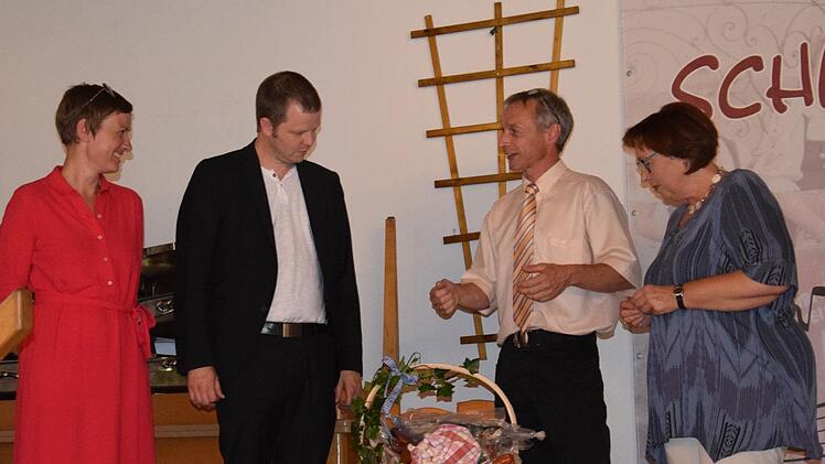 Christiane Binder-Jung (Kirchengemeinde Heiligkreuz), Reinhold Samer (Kirchengemeinde Weißenbach) übereichen dem Ehepaar Dr. Katharina Eberlein-Braun und  Pfarrer Thomas Braun einen Korb mit Rhöner Spezialitäten. Foto: Horst Conze