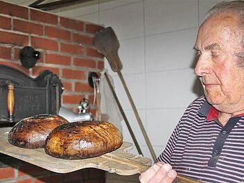 Ofenbauer Gottfried Schneid holt die fertigen Brote aus dem neuen Holzbackofen.  Fotos: Gerd Schaar