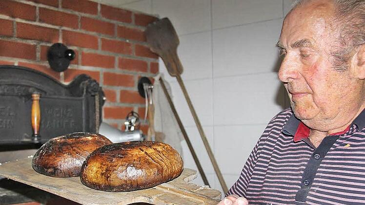 Ofenbauer Gottfried Schneid holt die fertigen Brote aus dem neuen Holzbackofen.  Fotos: Gerd Schaar