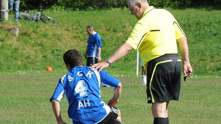 Fürsorge: Schiedsrichter Franz-Dieter Spiegl kümmert sich um den Oberwildfleckener Uli Weikard. Foto: Hopf