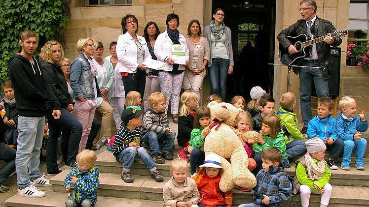 Übergabe von Urkunde und Maskottchen geschahen mit musikalischer Begleitung durch Landrat Michael Busch auf der Treppe zum Gemeindehaus. Foto: Klaus Oelzner