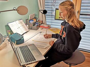 Pia Jäger im Videochat mit ihrer Lehrerin Frau Schneider und der Klasse. Sie korrigiert dabei ihre Hausaufgaben.  Foto: Iris Amon-Jäger