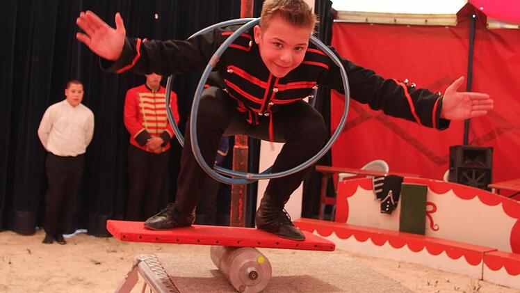 So sieht Carlos' Nummer in der Manege aus: Für seinen Balanceakt auf der Rolle, bei dem er sich in zwei Hula-Hoop-Reifen verknotet, muss er ständig üben - auch in den Wintermonaten. Foto: Sonja Adam