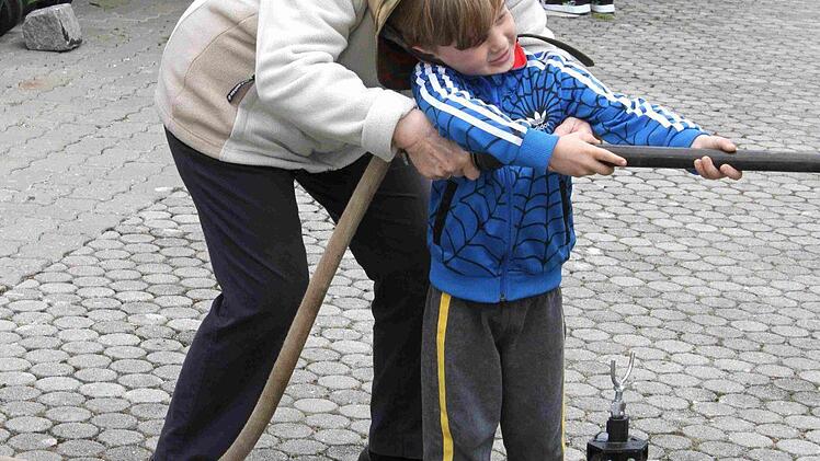Die kleinen Besucher übten mit der historischen Feuerwehrspritze. Foto: Richard Sänger