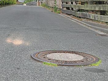 Die Kanalschachtdeckel im Kirchäckerweg müssen dringend saniert  und auf das vorgegebene Straßenniveau gebracht werden. Foto: Karl Heinz Wirth