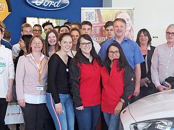 Die Schüler im Autohaus mit (v. l.) Lehrerin Susanne Schmidt, Wirtschaftsförderer Andreas Rösch (Landkreis Forchheim) und Ford-Geschäftsleiter Joachim Deusinger  Foto: Landratsamt Forchheim