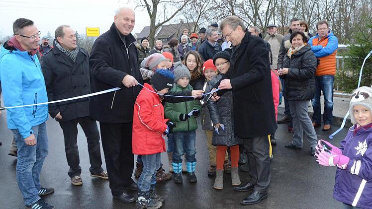 Bürgermeister Rainer Detsch, umrahmt von Kindern, durchschnitt im Beisein zahlreicher Bürger und Ehrengäste das Band und gab die Haßlachbrücke Wolfersdorf für den Verkehr frei.  Foto: K.-H. Hofmann