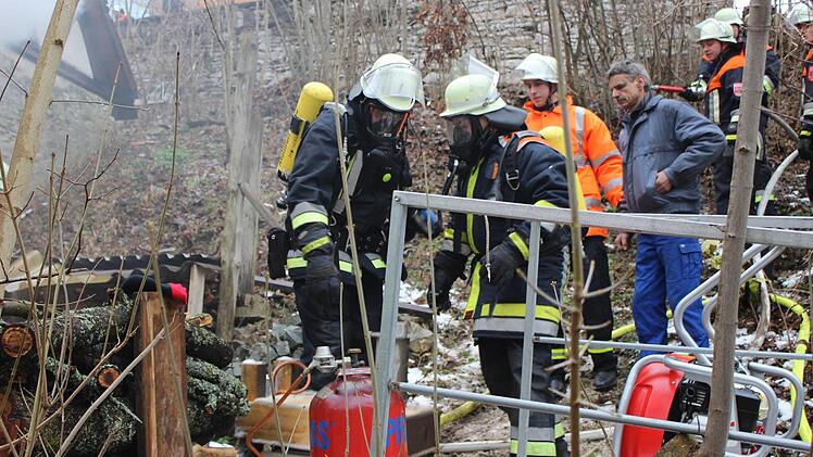 Die Feuerwehrler bergen eine Gasflasche.