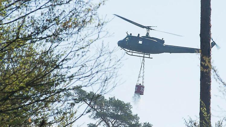 Ein Hubschrauber der Bundeswehr öffnet den Löschbehälter. Foto: Tobias Köpplinger