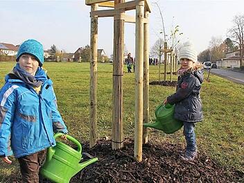 Lucas Väth (links) und Hanna Glückler gießen ihren Familienbaum, der an Hannas Geburtstag erinnern soll. Foto: Gerd Schaar