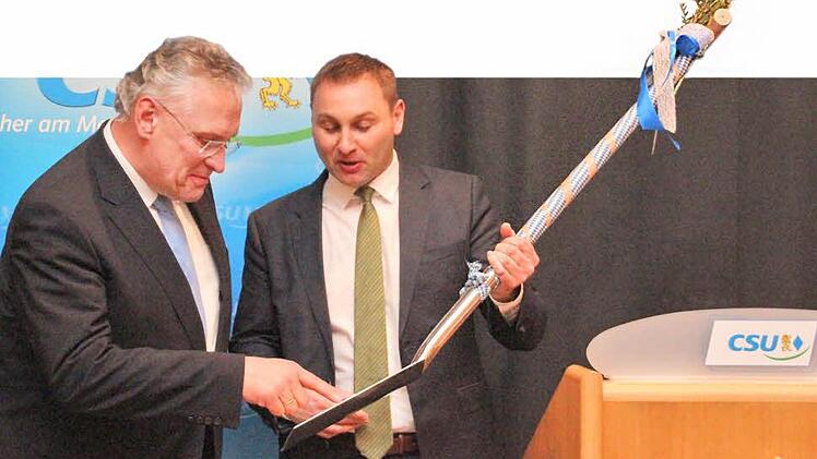 Einen Spaten zur Erinnerung an noch bevorstehende Straßenbauprojekte im Frankenwald schenkte Kreisvorsitzender Jürgen Baumgärtner (rechts) Innenminister Joachim Herrmann. Foto: Corinna Igler