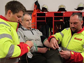 Matthias Hauke (links) und Torsten Hereth demonstrieren einen Einsatz der First Responder Gruppe der Zeitlofser Feuerwehr. Der 81-jährige Michael Schneider machte gerne bei der Übung mit, denn er hat schon mehrfach von der schnellen Hilfe profitiert. Foto: Ulrike Müller