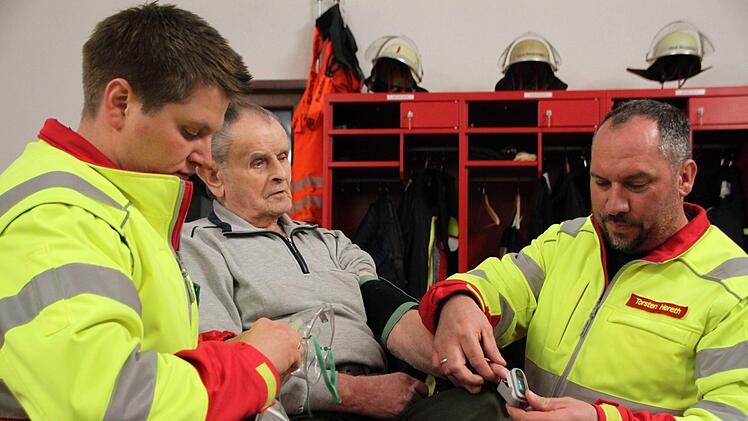 Matthias Hauke (links) und Torsten Hereth demonstrieren einen Einsatz der First Responder Gruppe der Zeitlofser Feuerwehr. Der 81-jährige Michael Schneider machte gerne bei der Übung mit, denn er hat schon mehrfach von der schnellen Hilfe profitiert. Foto: Ulrike Müller
