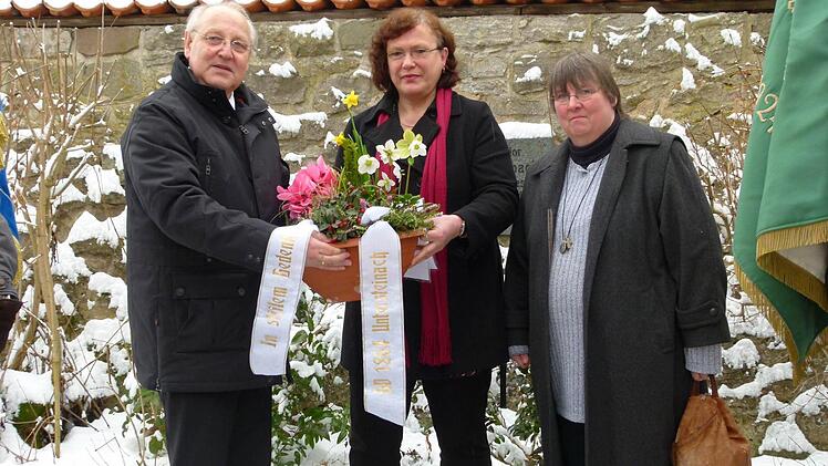 An der Gedenktafel legten (von links) dritter Vorsitzender Klaus Stump, Vorsitzende Christine Liebermann und stellvertretende Vorsitzende Christiane Lotter eine Schale nieder.