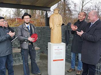 Bei der Enthüllung der Martin-Luther-Statue auf dem neuen Martin-Luther-Platz beim Wasserspielplatz in Bischofsheim (von links):  Ideengeber Bernhard Adrian,  Holzbildhauergeselle Johannes Brennsteiner, Pfarrer Matthias Schricker und Bürgermeister Georg Seiffert. Marion Eckert