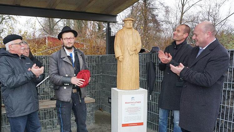Bei der Enthüllung der Martin-Luther-Statue auf dem neuen Martin-Luther-Platz beim Wasserspielplatz in Bischofsheim (von links):  Ideengeber Bernhard Adrian,  Holzbildhauergeselle Johannes Brennsteiner, Pfarrer Matthias Schricker und Bürgermeister Georg Seiffert. Marion Eckert