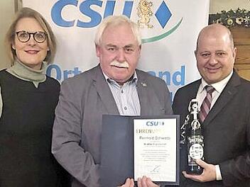 Holger Dremel (r.) und Andrea Weigler überreichen Reinhold Schweda die Ehrenurkunde. Foto: p
