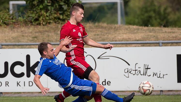 Szene aus dem Auftaktspiel: Der Mitwitzer Marc Parchent (blaues Trikot) grätscht gegen Patrick Titzmann vom FSV Buttenheim. Am Ende gewinnt der Aufsteiger im Steinachtal mit 2:1.  Foto: Heinrich Weiß