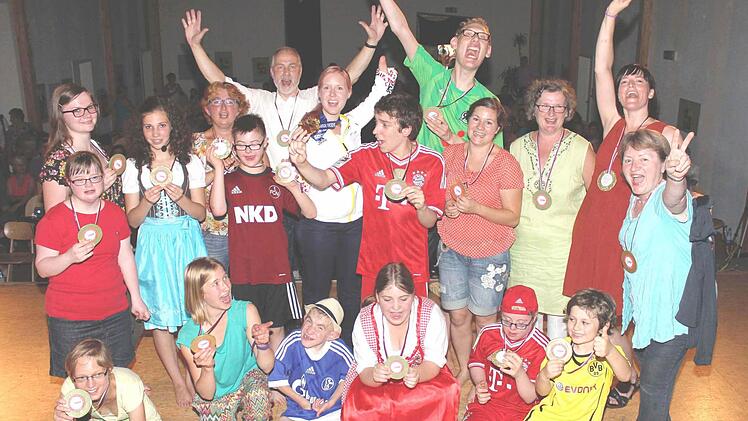 Eine Medaille für alle Beteiligten: Skirennläuferin und Paralympics-Slalomgewinnerin Andrea Rothfuss (mitte, 6. von links) war nach dem Lebenshilfe-Musical richtig begeistert. Auch von den Stücken von Liedermacher Martin Scherer (links daneben). Für alle gab es deshalb ebenfalls "Gold".