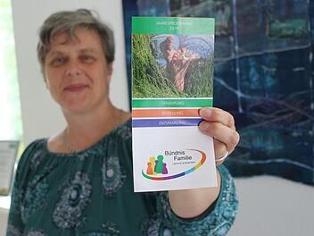 Projektkoordinatorin Lisa Kinalele hält den frisch gedruckten Programmflyer in der Hand. Foto: Julia Raab